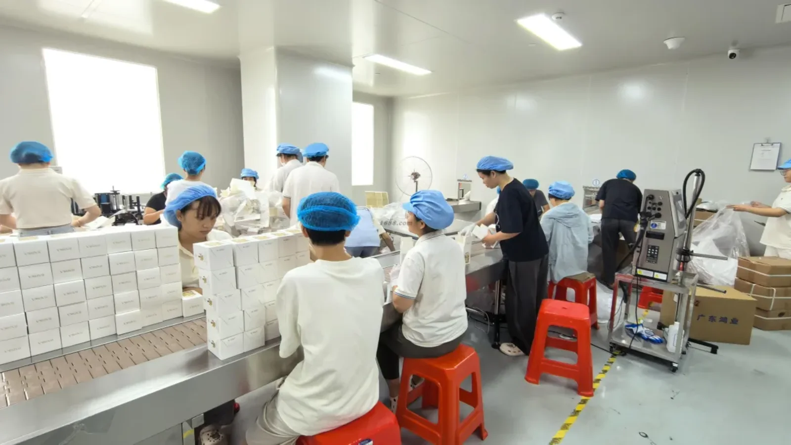 Factory team assembling and packing finished perfume products, relevant to perfume production lead time